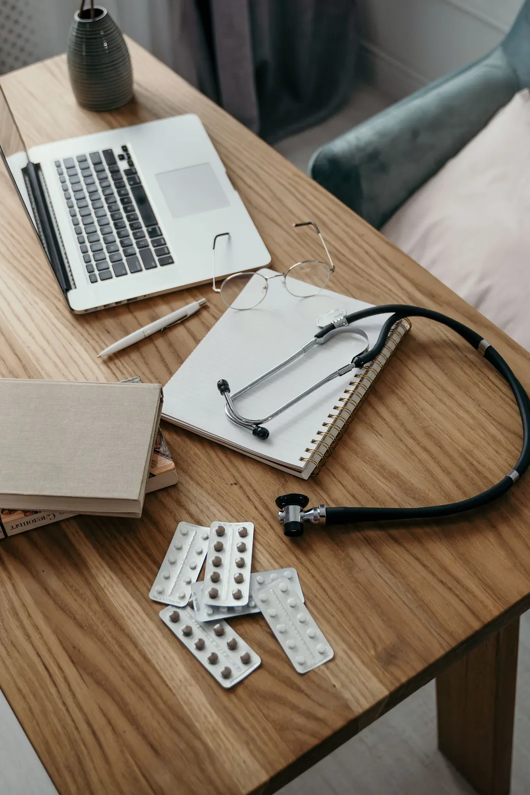 Medizinischer Arbeitsplatz mit Stethoskop, Fachbüchern und Laptop
