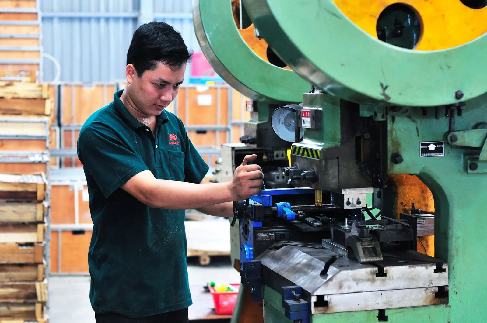 Mitarbeiter arbeitet an einer Maschine in einer Produktionshalle