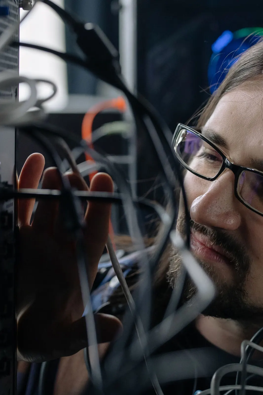 IT-Spezialist verbindet Netzwerkkabel im Serverraum